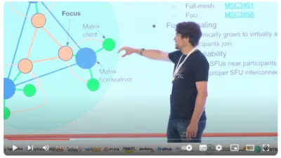 Screenshot of Matthew Hodgson gesturing at a diagram of how Matrix works, taken from the CommCon Youtube channel