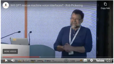Screenshot of the Youtube video of Rob Pickering on stage at CommCon 2023, giving his talk about conversational AI
